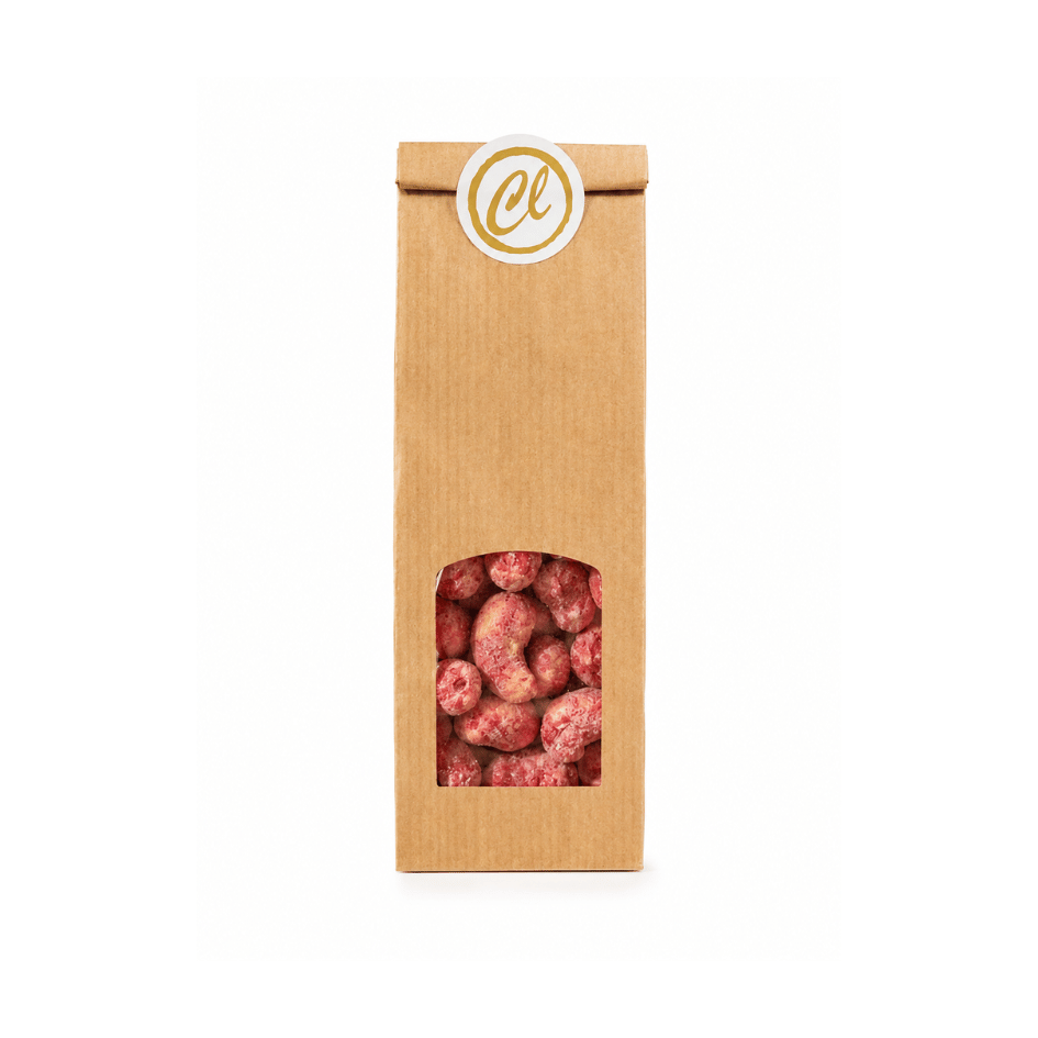 Himbeer-Cashewkerne mit weißer Schokolade und Himbeerstaub in brauner Papiertüte mit Sichtfenster.