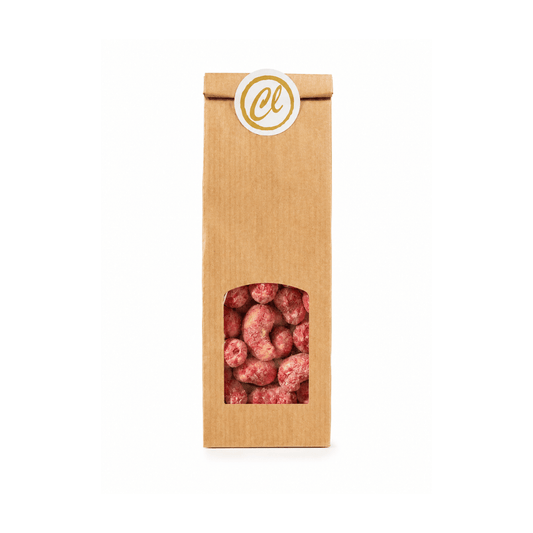 Himbeer-Cashewkerne mit weißer Schokolade und Himbeerstaub in brauner Papiertüte mit Sichtfenster.