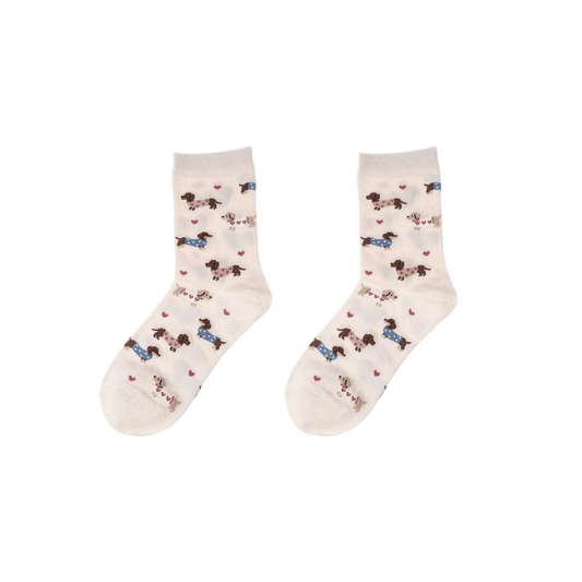 Cremefarbene Damen Socken mit Dackel-Motiv, kleinen Hunden in rosa und blauen Pullovern sowie rosa Herzchen, Größe 36–41.