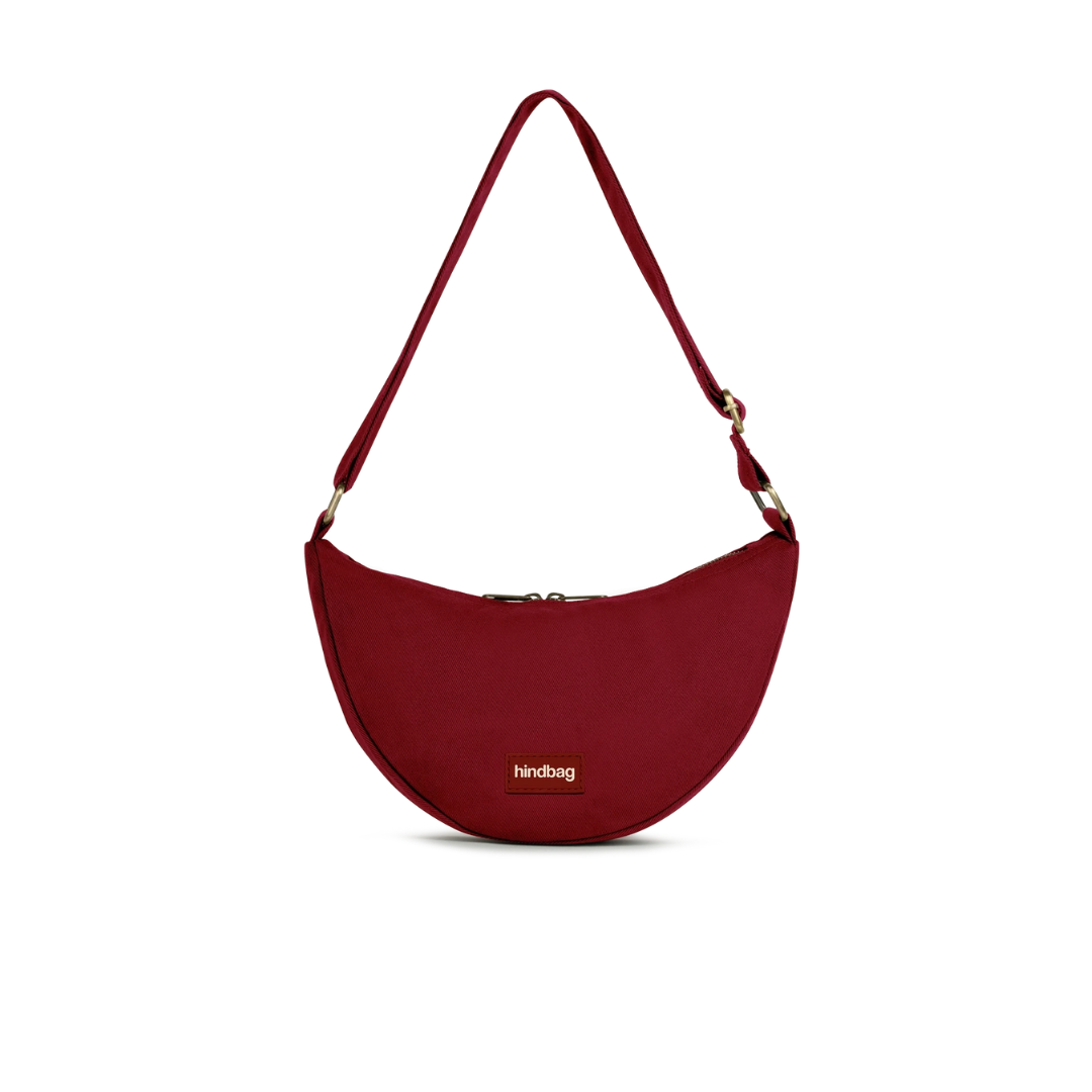 HINDBAG Andrea Bordeaux Halbmondtasche in tiefem Dunkelrot mit verstellbarem Schulterriemen und Reißverschluss, tragbar als Crossbody Bag oder Schultertasche.