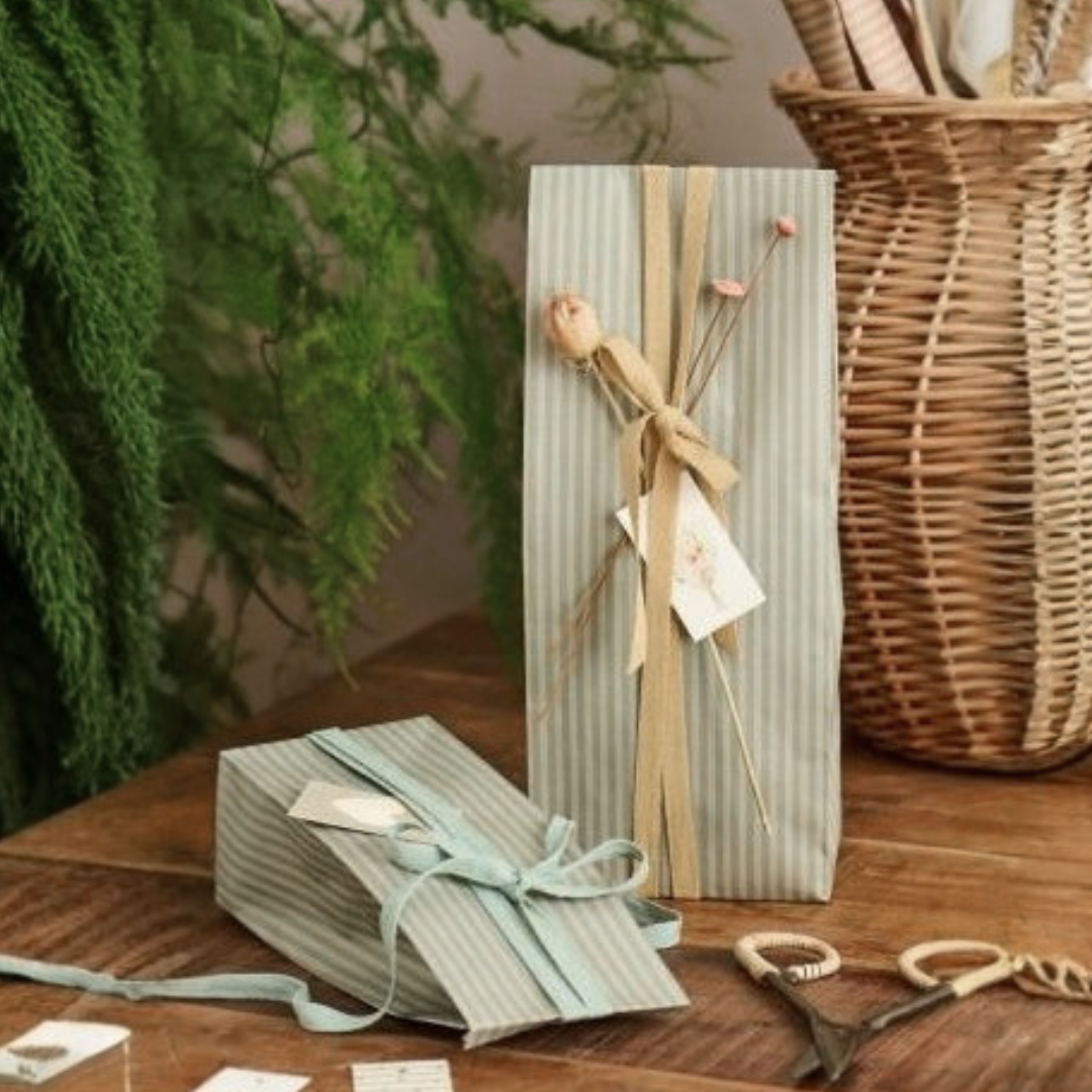 Kleine IB Laursen Geschenktüte aus 100 % recyceltem Papier mit feinen grünen Streifen und Bodenfalte, ca. 9 × 22,5 × 6 cm.
