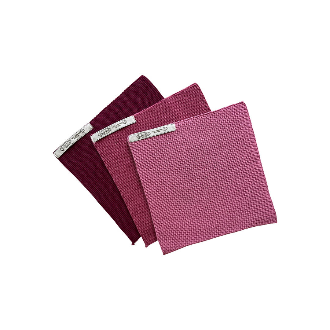 3er-Set gestrickte Wischtücher in abgestuften Dunkelrosa-, Rosé- und Beerentönen aus 100 % BIO Baumwolle, mit Schnur und Etikett gebunden.