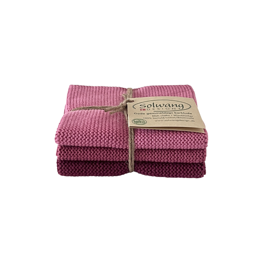 3er-Set gestrickte Wischtücher in abgestuften Dunkelrosa-, Rosé- und Beerentönen aus 100 % BIO Baumwolle, mit Schnur und Etikett gebunden.