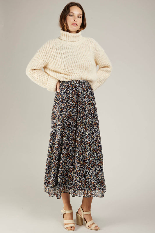 langer rock mit golddetailss und floralem muster