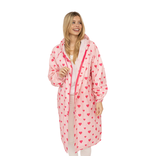 Zwillingsherz Regenmantel Love in Rosa mit pink-rotem Herzchenprint, Kapuze, langen Ärmeln und langem Schnitt.